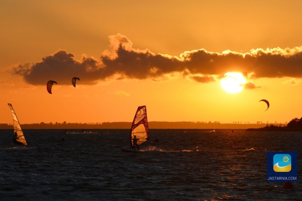 Windsurfing i kitesurfing o zachodzie słońca.